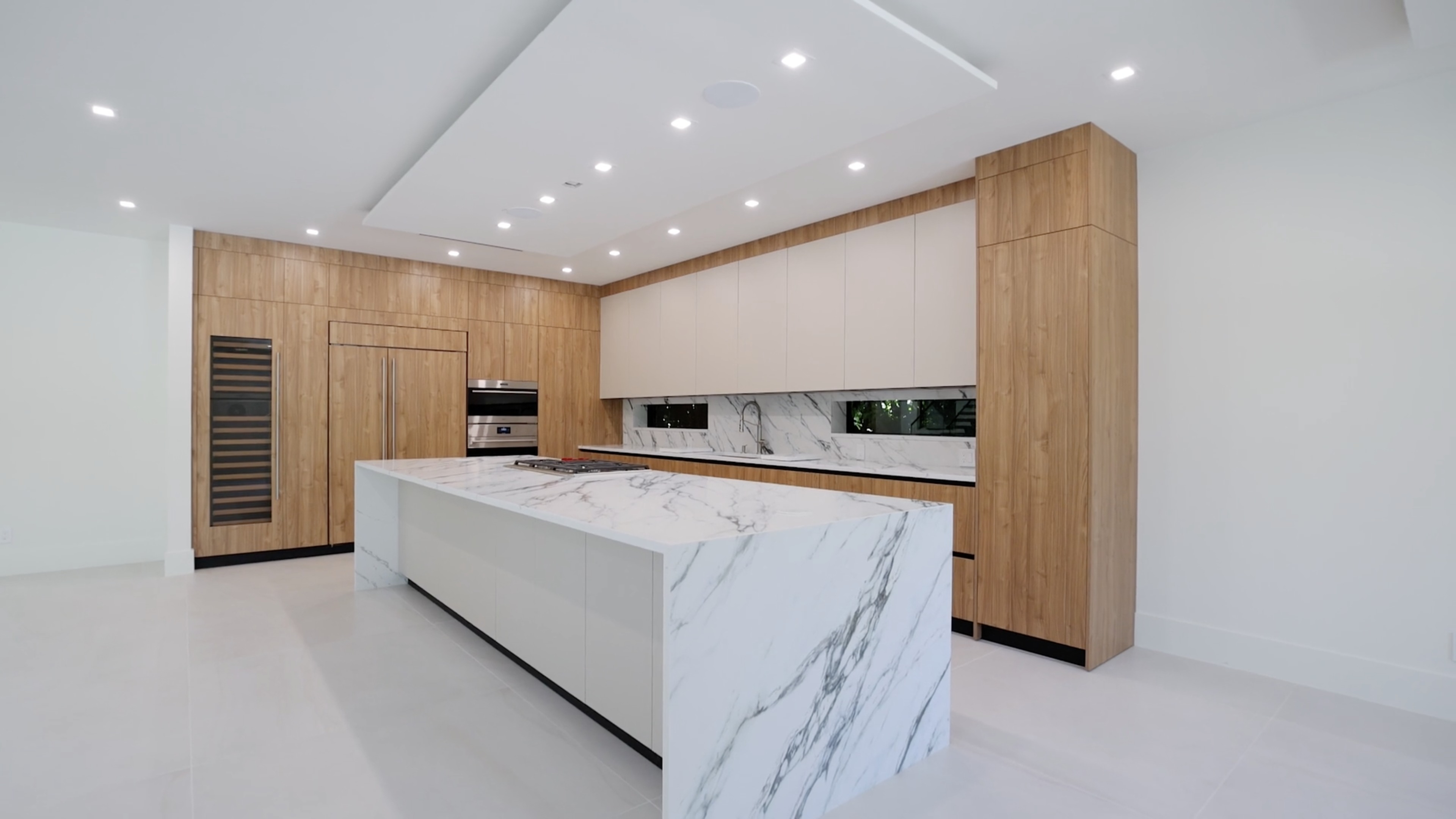 Lunaro Cabinetry custom kitchen with millwork and waterfall marble island in the Tarpon Residence, Fort Lauderdale